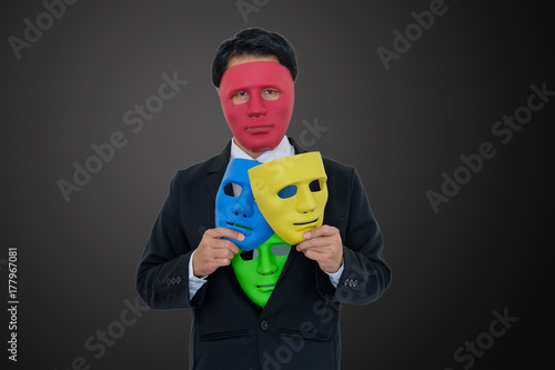 Businessmen wear red mask and hide many masks in suit.