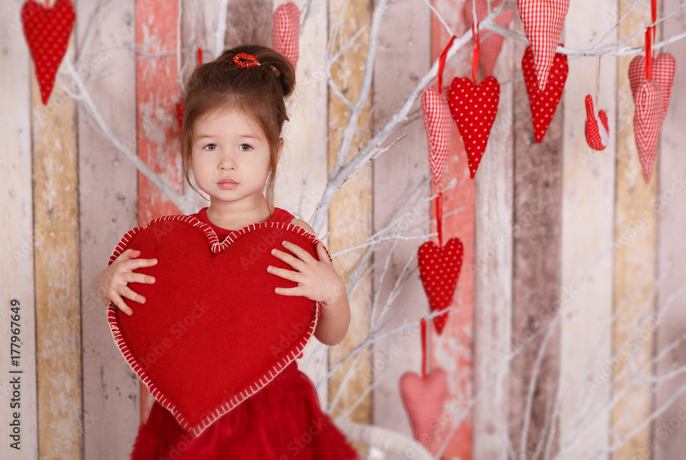 Young brunette dolly lady girl stylish dressed in red dress strap shoes smiling posing sitting in studio and holding big huge heart with pout lips and pink cheeks. Young brunette dolly lady girl stylish dressed in red dress strap shoes smiling posing sitting in studio and holding big huge heart with pout lips and pink cheeks.
