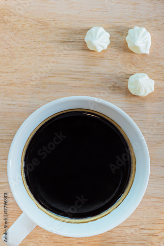 Coffee cup and cookie on a wooden table, selective focus (detailed close-up shot)