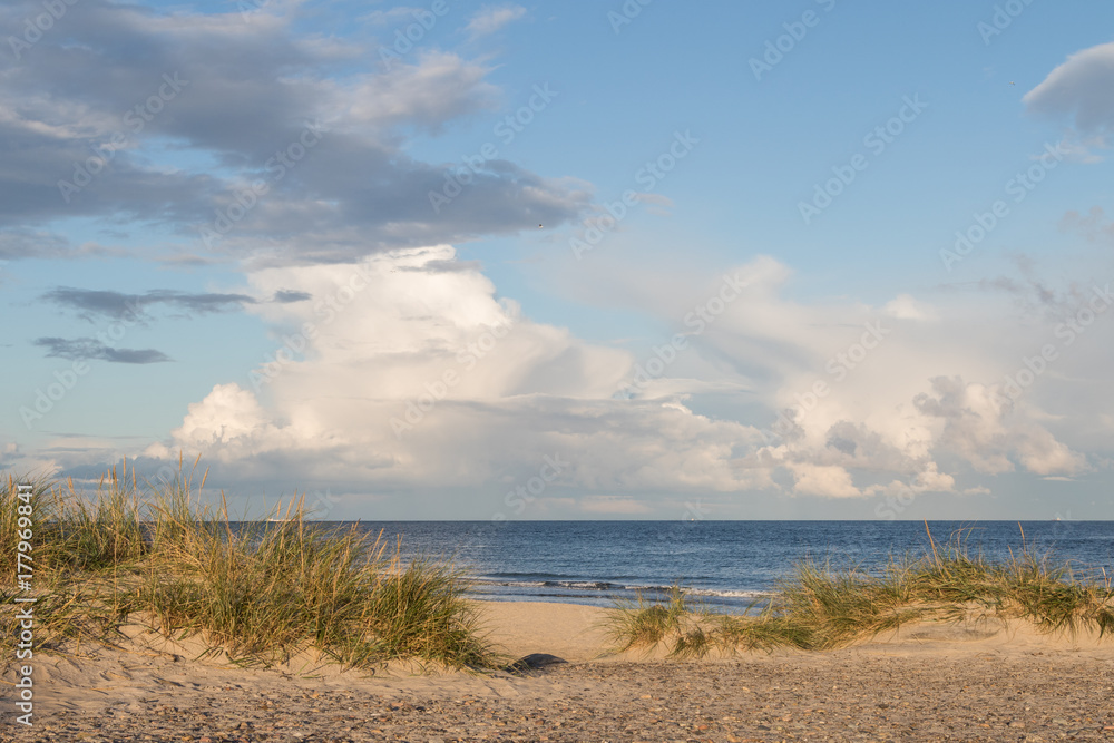 Beach, ocean and blue sky with clouds at Grenen Skagen in Denmark