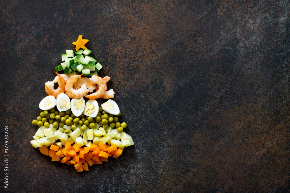 Christmas tree from a salad olivier on a brown rusty stone or metal background. Top view with a copy.