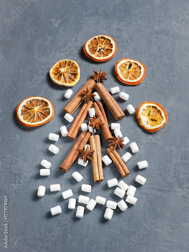 Christmas spices cinnamon, star anise, marshmallow oranges on a concrete background