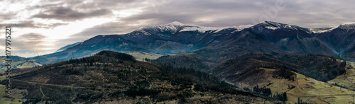 panorama of mountainous countryside in late autumn. great Borzhava mountain ridge with snowy Velykyi Verkh peak at sunrise