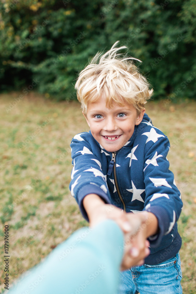 boy twirling around while holding his mother's hand boy twirling around while holding his mother's hand