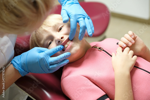 The doctor examines the teeth of a little girl in a dental clinic
