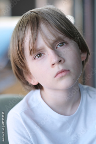 Portrait of a sitting tired boy with a sad look