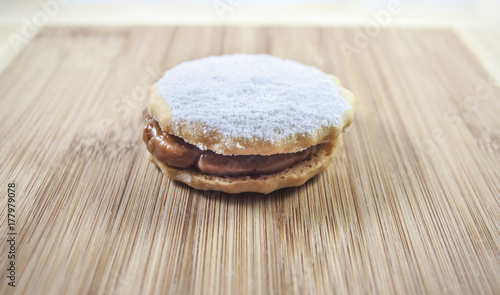 Fototapeta Naklejka Na Ścianę i Meble -  Alfajor cookie whit white sugar over wood table