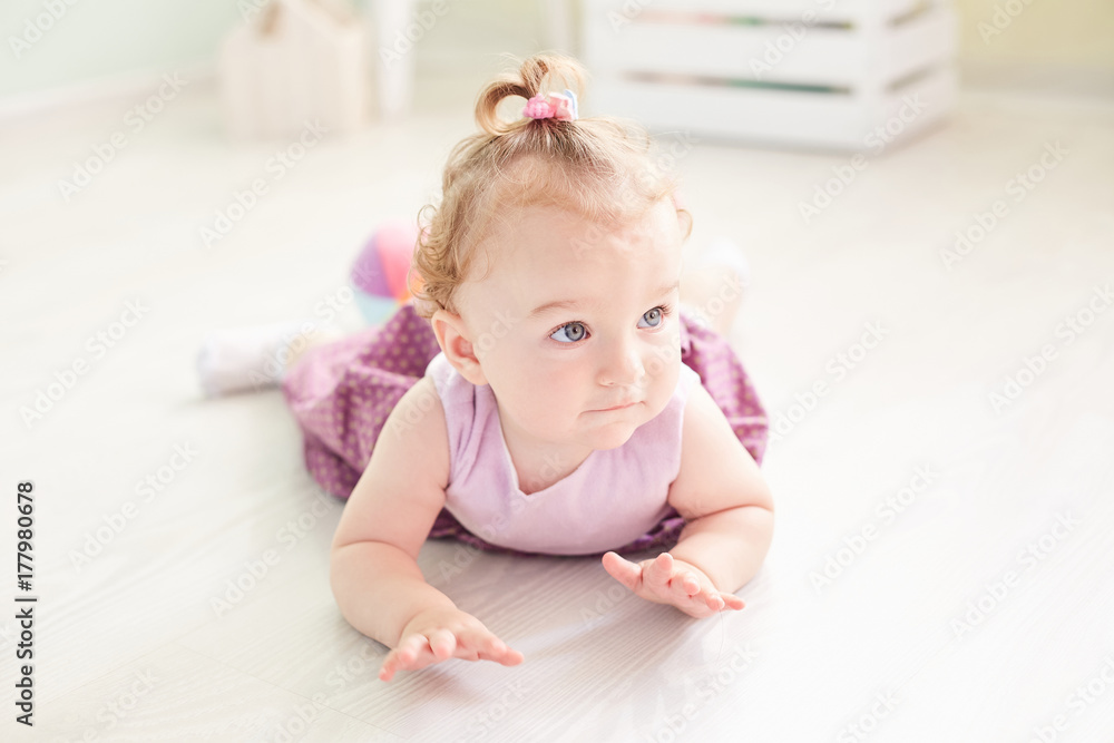 Adorable little baby girl laughing, smiling, creeping amp. playing in the studio wearing dress Adorable little baby girl laughing, smiling, creeping amp. playing in the studio wearing dress