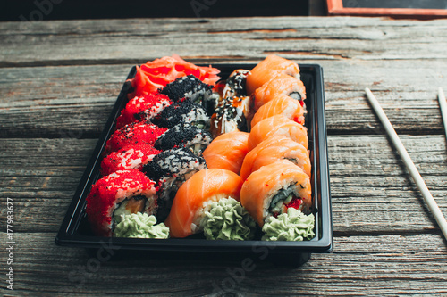 on a wooden table in the black container are nicely decomposition sushi photo