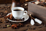 Black coffee in a white cup and various spices