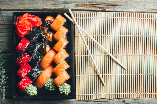 on a wooden table in the black container are nicely decomposition sushi photo