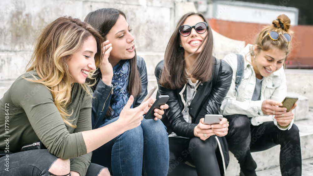Four girl friends happy watching internet social media in smartphone