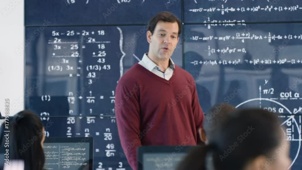 Teacher in adult education class explaining math formulas to students Teacher in adult education class explaining math formulas to students