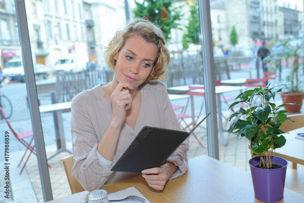 woman looking at menu for ordering food in restaurant woman looking at menu for ordering food in restaurant