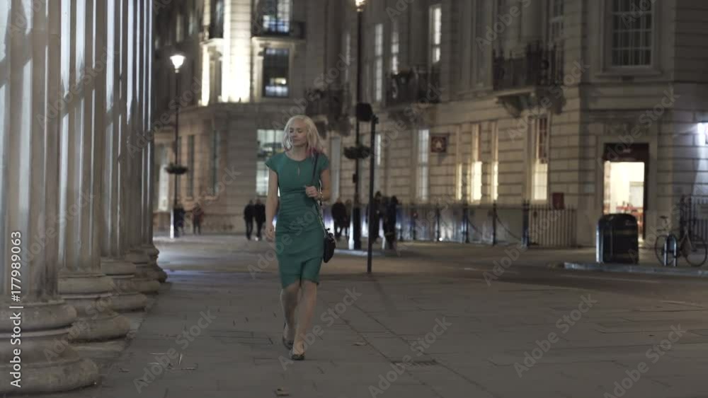 Attractive woman in evening wear walking alone in the city at night. Attractive woman in evening wear walking alone in the city at night.