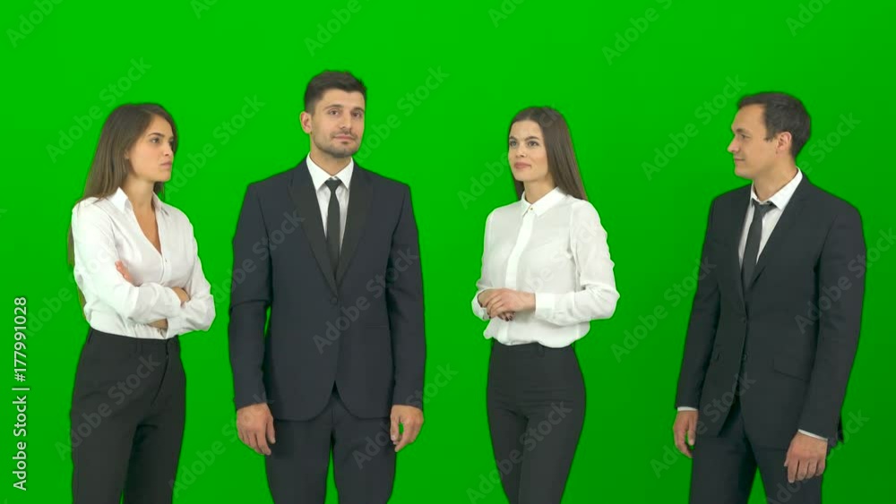 The four business people work with a virtual screen on the green background The four business people work with a virtual screen on the green background