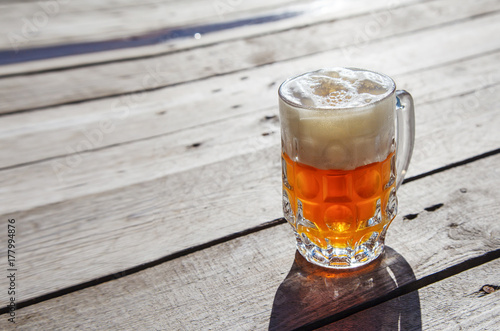 glass mug with beer standing on the table outdoor