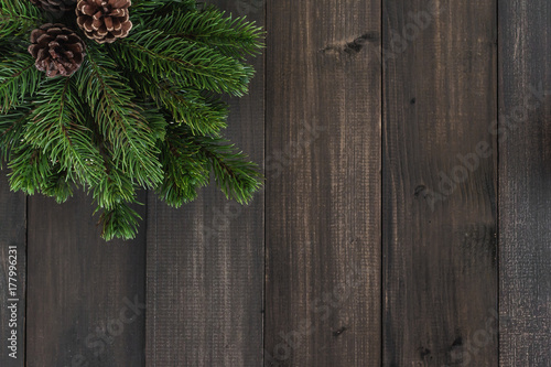 Christmas fir tree branches and pine on dark rustic wooden background with copy space for text
