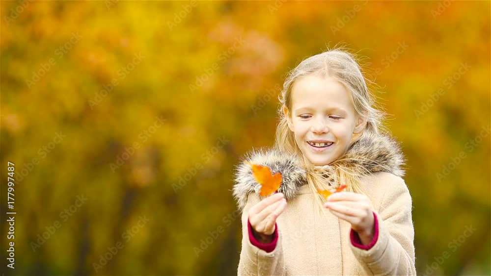 Little kid outdoors have fun at beautiful warm day with yellow leaf in fall Little kid outdoors have fun at beautiful warm day with yellow leaf in fall