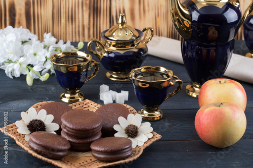 coffee on the table with background with cakes and apples