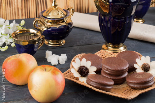 coffee on the table with background with cakes and apples