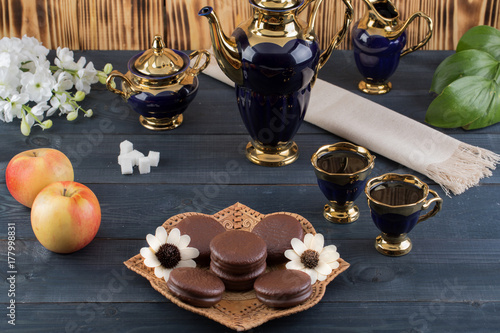 coffee on the table with background with cakes and apples
