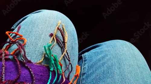 legs - knees of sitting woman with fringe from scarf photo