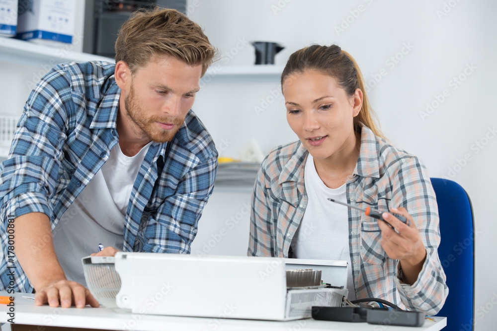 Young technician asking advice from colleague Young technician asking advice from colleague