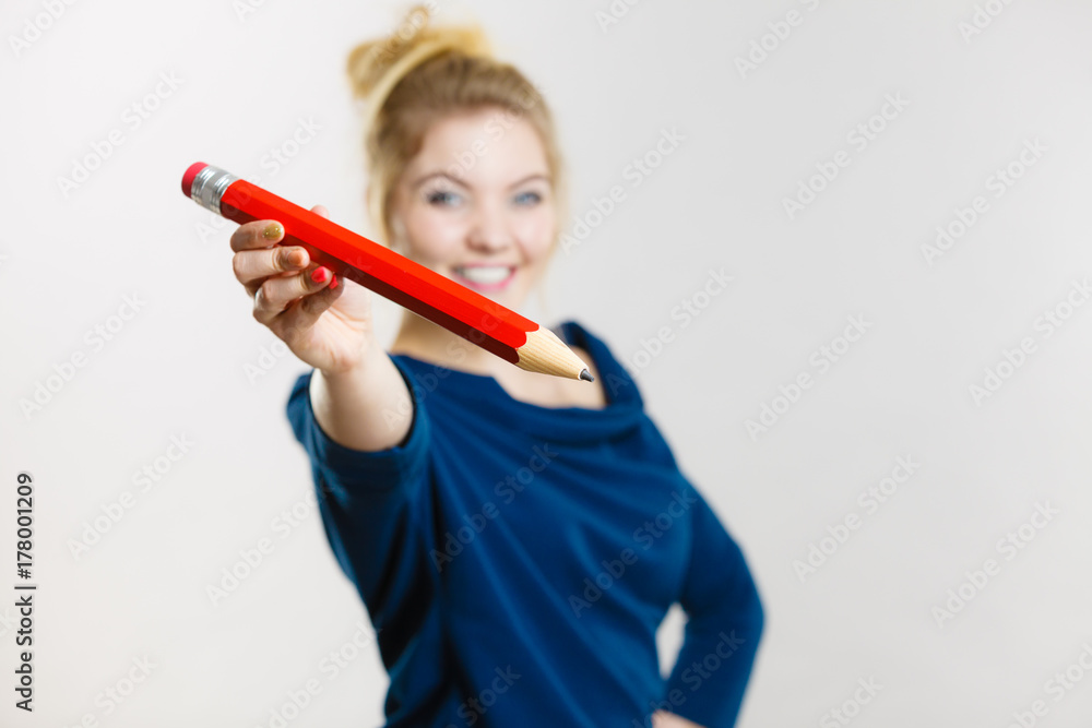 Happy woman holding giving big pencil Happy woman holding giving big pencil