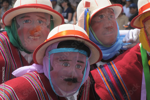 People in traditional Ecuadorean masks dance as a part of a parade celebrates its Spanish Foundation of the city Quito, Ecuador photo