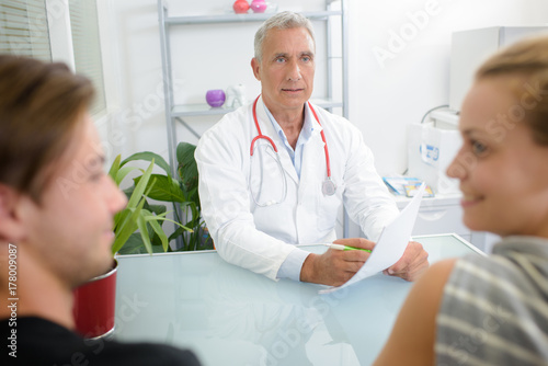Doctor giving good news to young couple