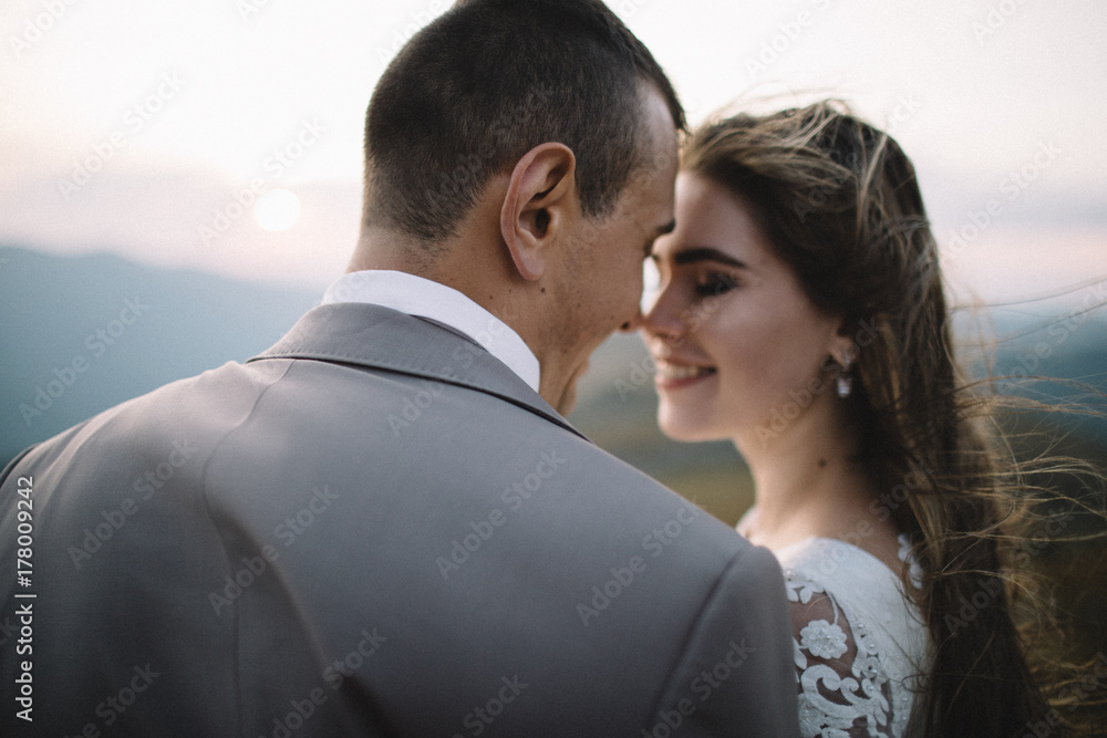 Romantic couple standing together holding hands in the mountains Romantic couple standing together holding hands in the mountains