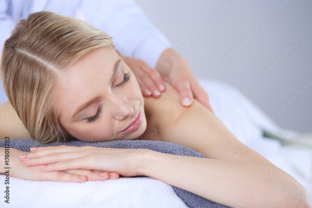 Young woman lying on a massage table,relaxing with eyes closed. Woman. Spa salon