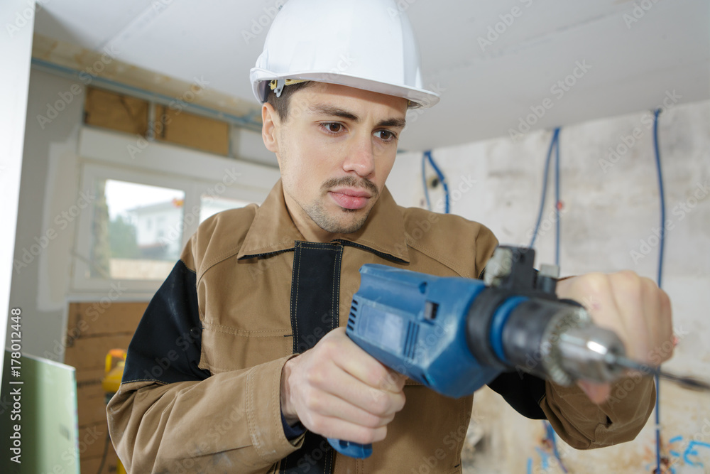 Workman using electric drill Workman using electric drill