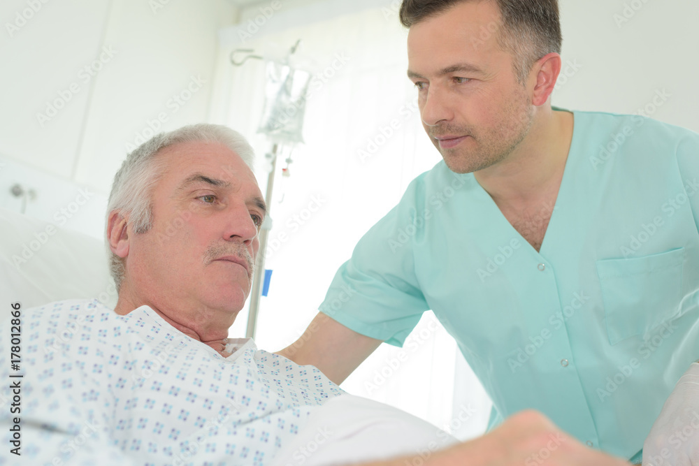 doctor looking at patient on bed doctor looking at patient on bed