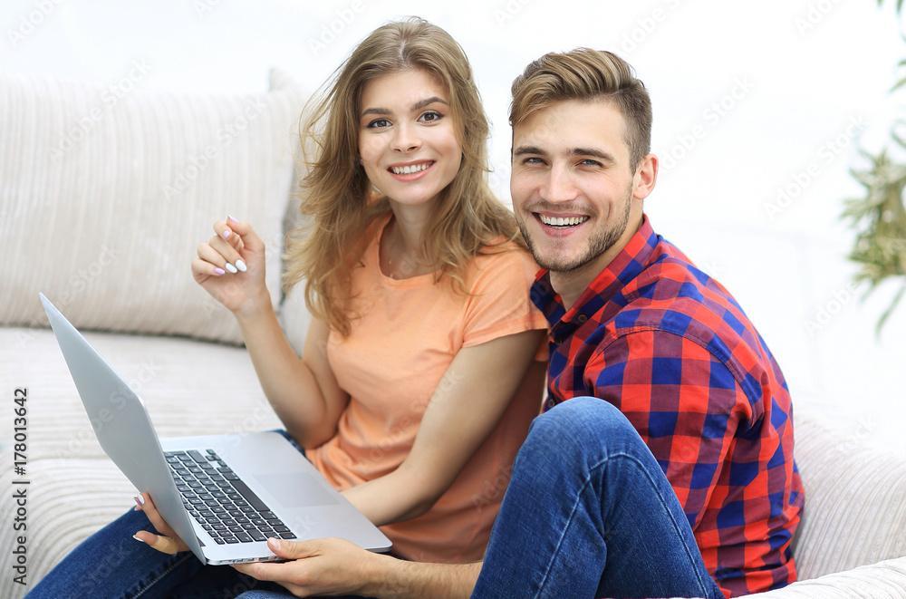 pair students with a laptop sitting on sofa