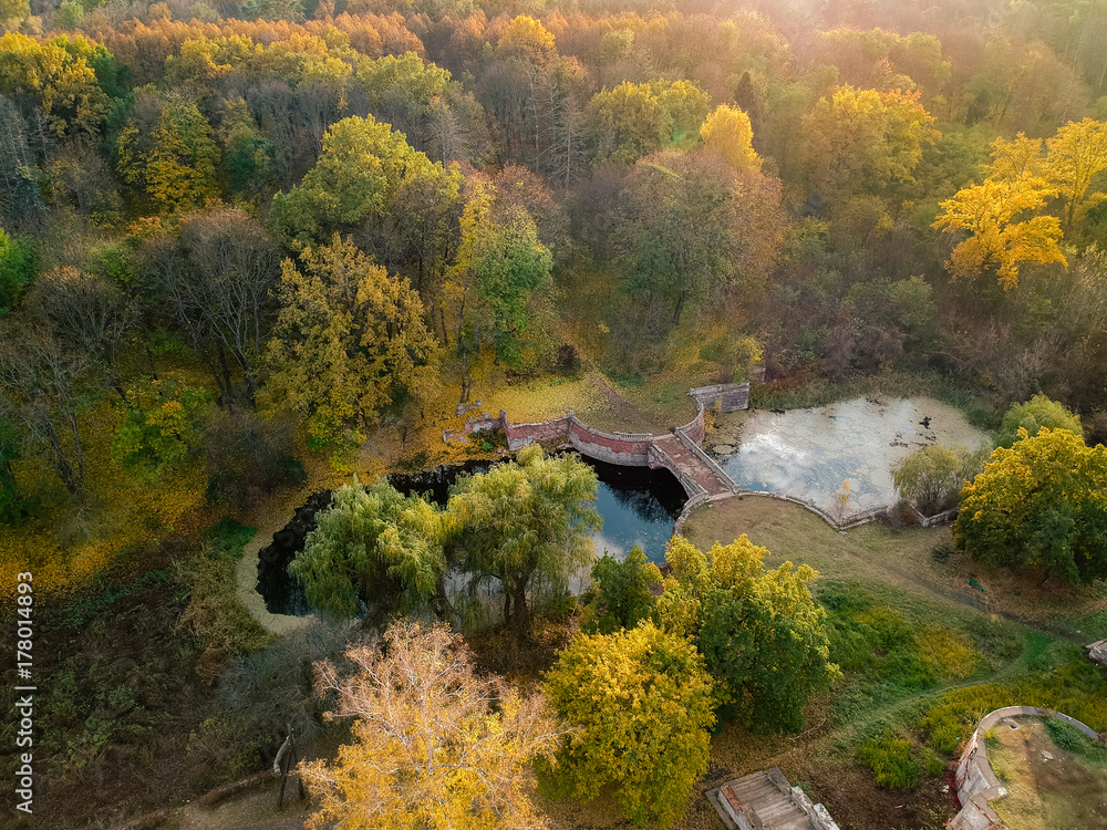 Aerial view on abandoned ruined castle and park. Autumn color image in sunset light.