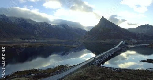Car drives on a country road in a stunning epic landscape with mountains in the background