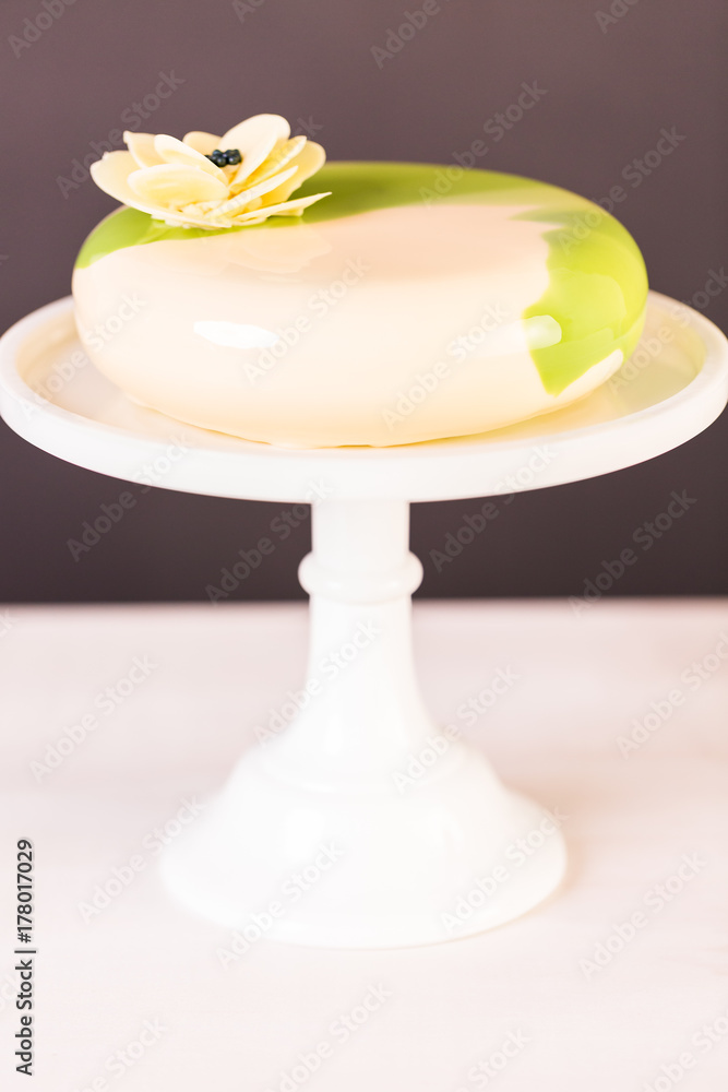 top view of homemade mousse cake decorated with green mirror glaze, white  roses, coconut chips and macaroons Stock Photo - Alamy