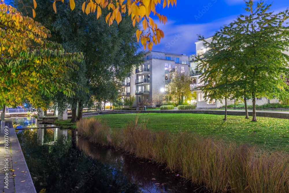 Fotografie En kanal inne i Hammarby sjöstad med små broar, trappor och dekorativa däck med