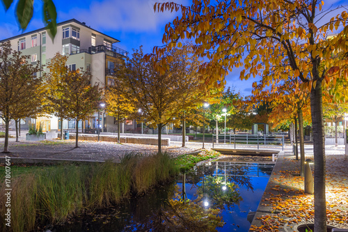 En kanal inne i Hammarby sjöstad med små broar, trappor och dekorativa däck med pelar runt finns runt denna kanal photo