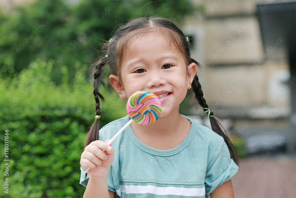 Close-up happy asian little girl with lollipop candy. Focus at her face. Close-up happy asian little girl with lollipop candy. Focus at her face.