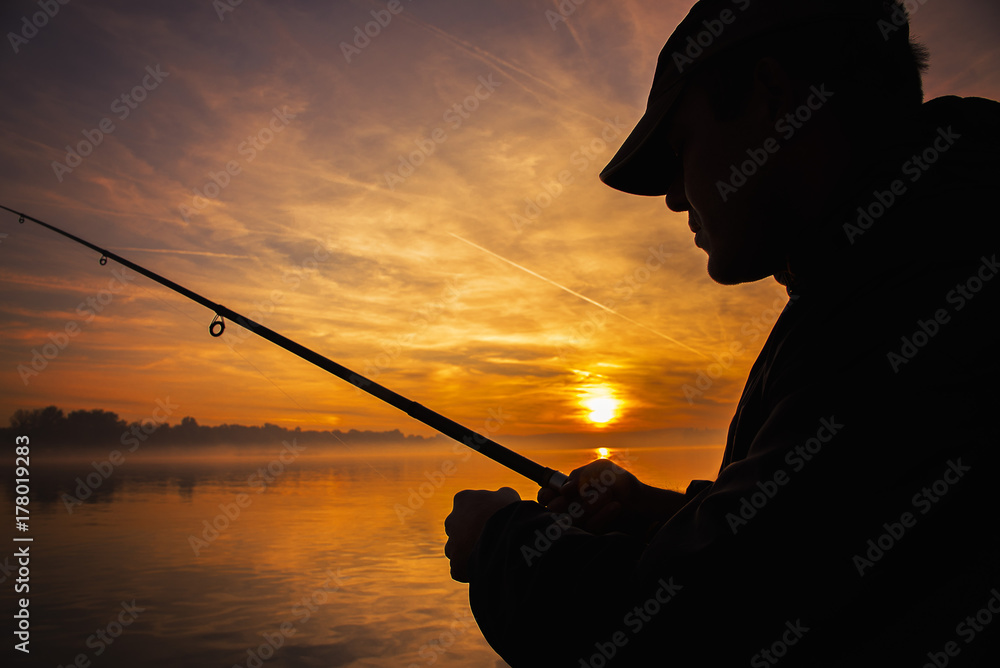 Φωτογραφία Fisherman throwing his rod, fishing from a little boat, beautiful morning sunris