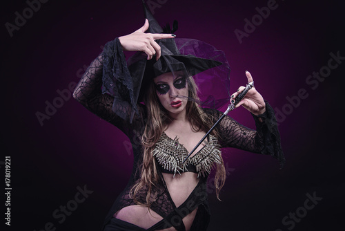 Halloween concept, sexy evil witch with her wand