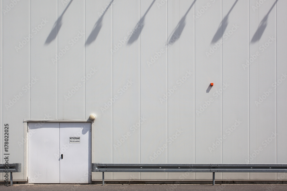 White wall, exit door and lamp shadows White wall, exit door and lamp shadows