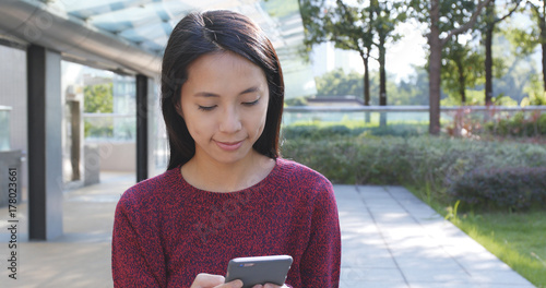 Woman working on cellphone at outdoor photo