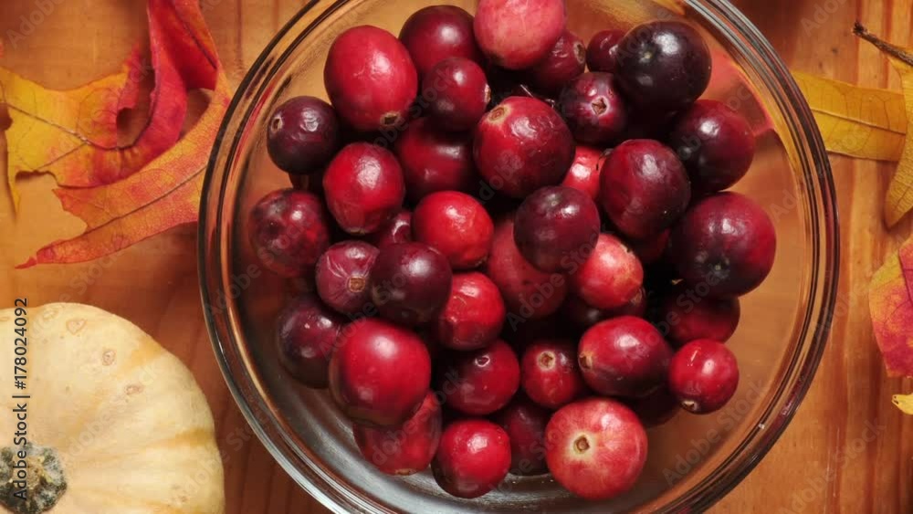 Overhead zoom out shot of a bowl of cranberries on a holiday setting
Overhead zoom out shot of a bowl of cranberries on a holiday setting