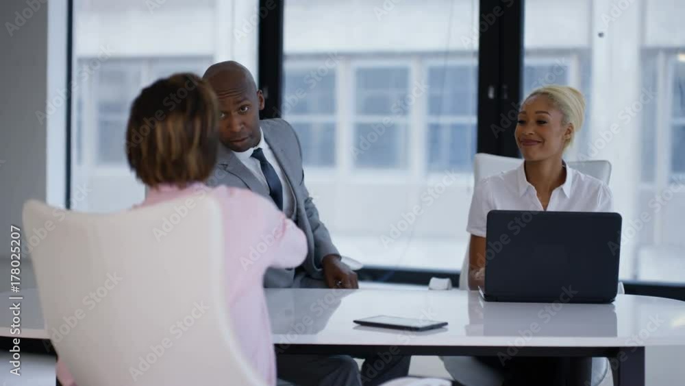 Business managers interviewing potential employee and shaking hands at end of meeting. Business managers interviewing potential employee and shaking hands at end of meeting.