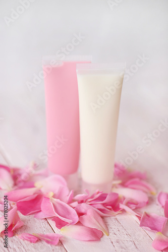 Cosmetic bath set with rose extract. Shower gel and body lotion with rose petals on a wooden background. Organic Natural Cosmetics Concept. Cosmetic rose serie © Yuliya