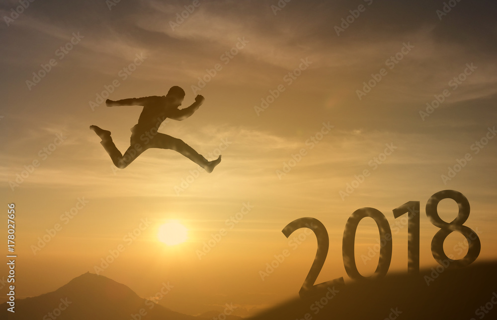 2018 brave man successful concept,silhouette man jumping over the sun between gap of the mountain to 2018 new year, feel like a winner, success, finish,reach a goal of live, jobs,work in year coming